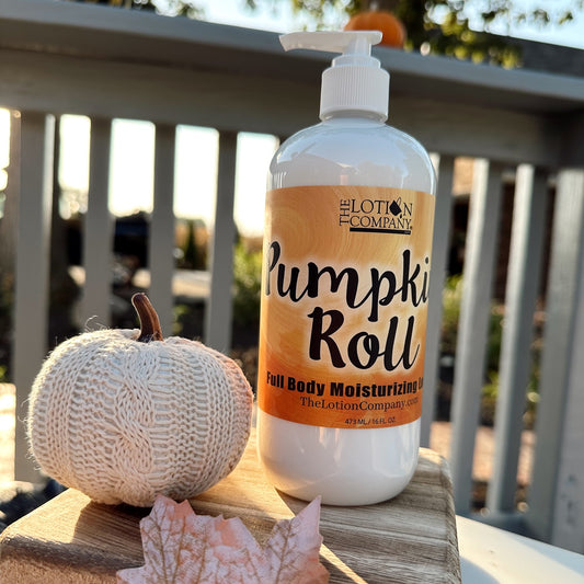 Bottle of 'Pumpki Roll' body moisturizer with a decorative pumpkin on a wooden surface.